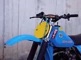 a blue and yellow dirt bike parked in front of a wall