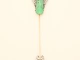 a close up of a green and white broocher on a stick