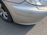 a close up of a car ' s front bumper with a cat on it
