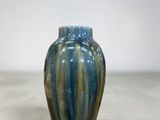 un vase bleu et vert posé par terre