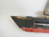 un bateau en bois orné d'une bande rouge et noire