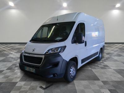la camionnette blanche est garée dans une grande pièce au sol en damier