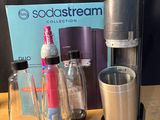 une cafetière, une tasse et une bouteille posées sur une table