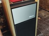 a small refrigerator sitting in the middle of a kitchen
