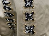 the back of a jacket with gold and black buttons on it