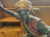 a statue of a man sitting on top of a chair