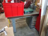 a red bin sitting on top of a workbench in a garage