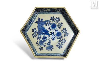 une assiette bleue et blanche ornée d'un oiseau et de fleurs