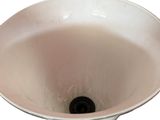 a white sink with a black drain in it