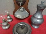 une horloge en argent posée sur une table rouge, à côté d'autres objets en argent