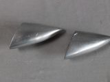 two pieces of metal on a table with a gray background