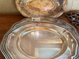 deux assiettes en argent posées sur une table en bois, avec une paire de ciseaux