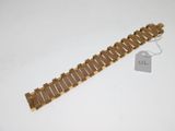a close up of a gold bracelet with a tag on it