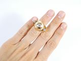 a woman ' s hand holding a ring with a diamond on it