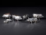a group of silver figurines of animals on a black surface