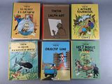 six children ' s books are lined up in a row on a table