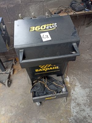 une boîte noire sur laquelle est collé un autocollant jaune, posée par terre