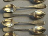 six spoons are lined up in a row on a table