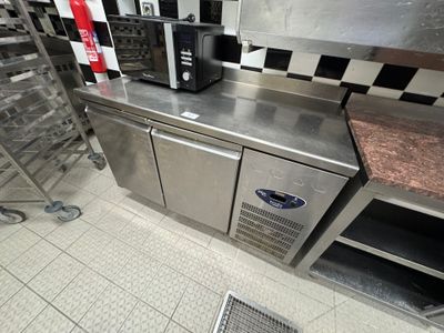 stainless steel counter top in a commercial kitchen with ovens and other appliances