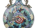 a vase that has a bird on it and flowers on it