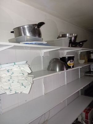 de nombreuses casseroles et poêles sur les étagères de la cuisine