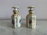 two white and gold vases sitting on a marble table