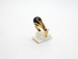 a close up of a gold ring with a black stone on it