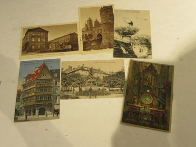several old postcards of buildings and a clock on a table