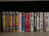 many dvd ' s on a shelf in a library