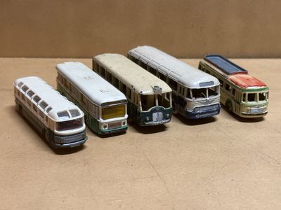 cinq petits bus alignés en rang sur une table