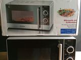 two microwaves sitting on top of each other on a table