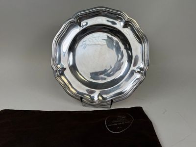 un plateau en argent recouvert d'un tissu noir posé sur une table blanche