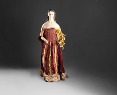 une image représentant une femme vêtue d'une robe rouge et dorée, debout devant un fond noir