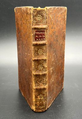 an old book sitting on top of a table next to a black table
