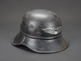 an old helmet with a winged emblem on it on a gray background