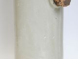 a white vase with a cork sticking out of it