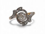 un gros plan d'une bague en diamant et en or sur fond blanc