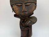 une image représentant une sculpture en bois d'une personne portant un chapeau