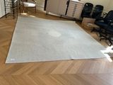un grand tapis blanc posé au sol dans une pièce