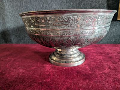 a silver bowl sitting on a red table cloth