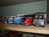 de nombreuses petites voitures et de nombreux petits bus sur une étagère dans une pièce