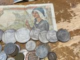 a pile of coins on a table next to a bank note