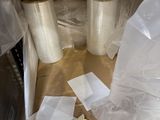 de nombreux rouleaux de film alimentaire posés par terre à côté d'un micro-ondes