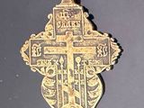 une croix dorée sur une surface noire, avec un fond noir