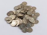 a pile of silver coins on a white surface