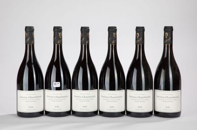six bouteilles de vin sont alignées sur une table