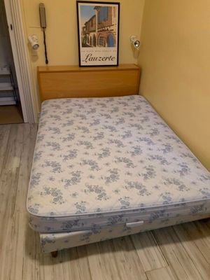 un lit qui se trouve dans une petite chambre avec un tableau accroché au mur