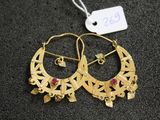 une paire de boucles d'oreilles créoles en or ornées de pierres rouges