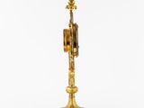 an antique brass clock on a stand with a pendulum on it