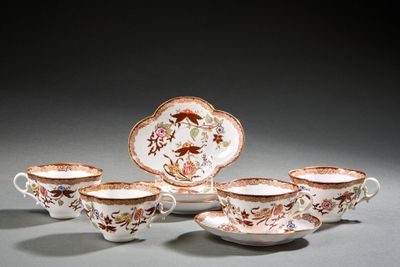quatre tasses et soucoupes sont posées sur une surface grise